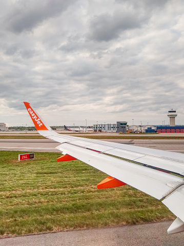 Gatwick Airport, England, UK - Wing of Easyjet aircraft after landing against backdrop of airport control tower