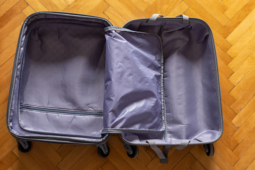 From above photo of a empty suitcase on a wooden floor