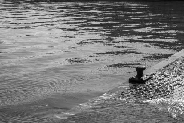 ship docked in port with calm sea in black and white