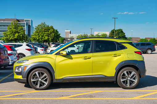 A green colored Hyundai Kona is parked in a parking lot in Burlington, Ontario, Canada on a sunny day.