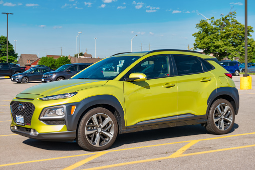 A green colored Hyundai Kona is parked in a parking lot in Burlington, Ontario, Canada on a sunny day.