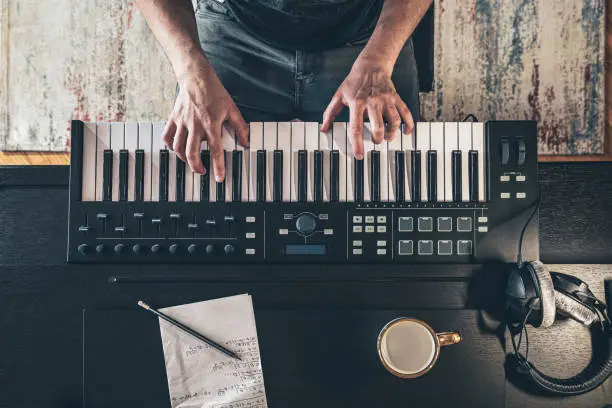 Photo of Male hands on the piano keys, top view.