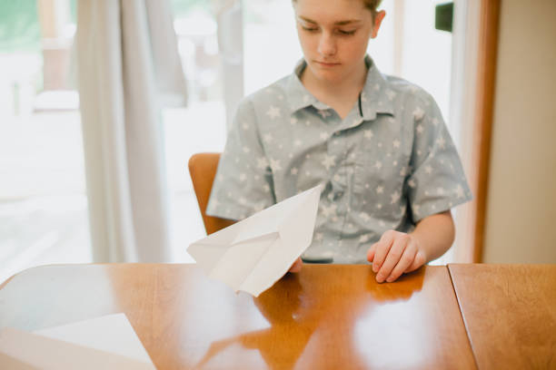 istock Teenage Boy Making Paper Airplane 1404719725