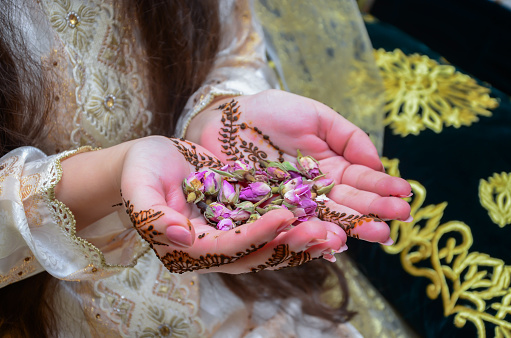 Henna Tattoo on Bride's Hand.Moroccan wedding preparation henna party. Temperate white mehndi. Modern mehendi art.