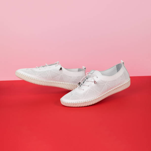 istock Walking white shoes on a red and pink background. 1404720794