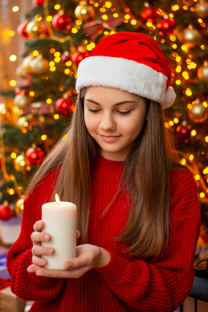 istock Small girl in Santa hat with burning candle 1404720907