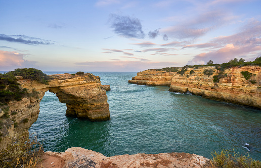 Sunrise at Albandeira Arch at Praia de Albandeira's beautiful rocky coast and beach on the famous Algarve Coast in southern Portugal, Europe.