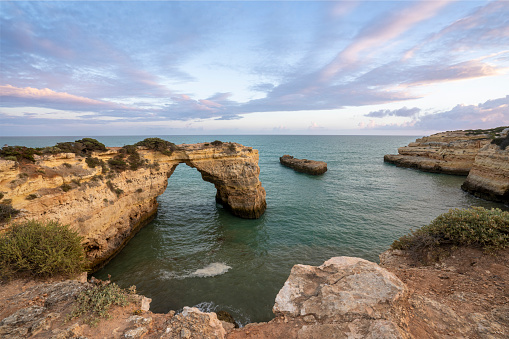 Sunset at Albandeira Arch at Praia de Albandeira's beautiful rocky coast and beach on the famous Algarve Coast in southern Portugal, Europe.