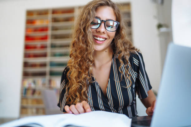 istock Young beautiful student girl working, learning in college library. 1404726290
