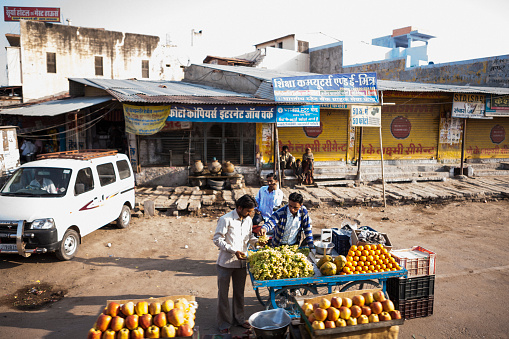This image offers a glimpse into Margao's vegetable market in Goa, a vibrant marketplace teeming with fresh produce and local flavours. Stalls are adorned with a colourful array of fruits and vegetables, from locally-grown staples like okra and eggplant to exotic offerings like dragon fruit and rambutan. The atmosphere is lively, filled with the chatter of vendors and customers, and the air is perfumed with the earthy scent of fresh produce. The photograph aims to capture the essence of the market, portraying it as a hub of local activity where the community comes together to shop, socialise, and experience the bounty of Goa's agricultural offerings.
