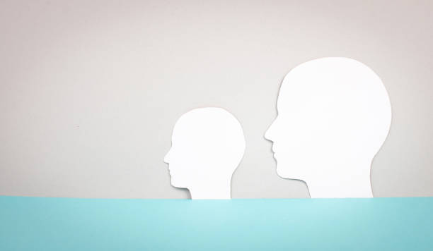 istock Two silhouette faces looking to the same direction, copy space for text, adult and child, anonymous profil of men, communication concept 1404733186
