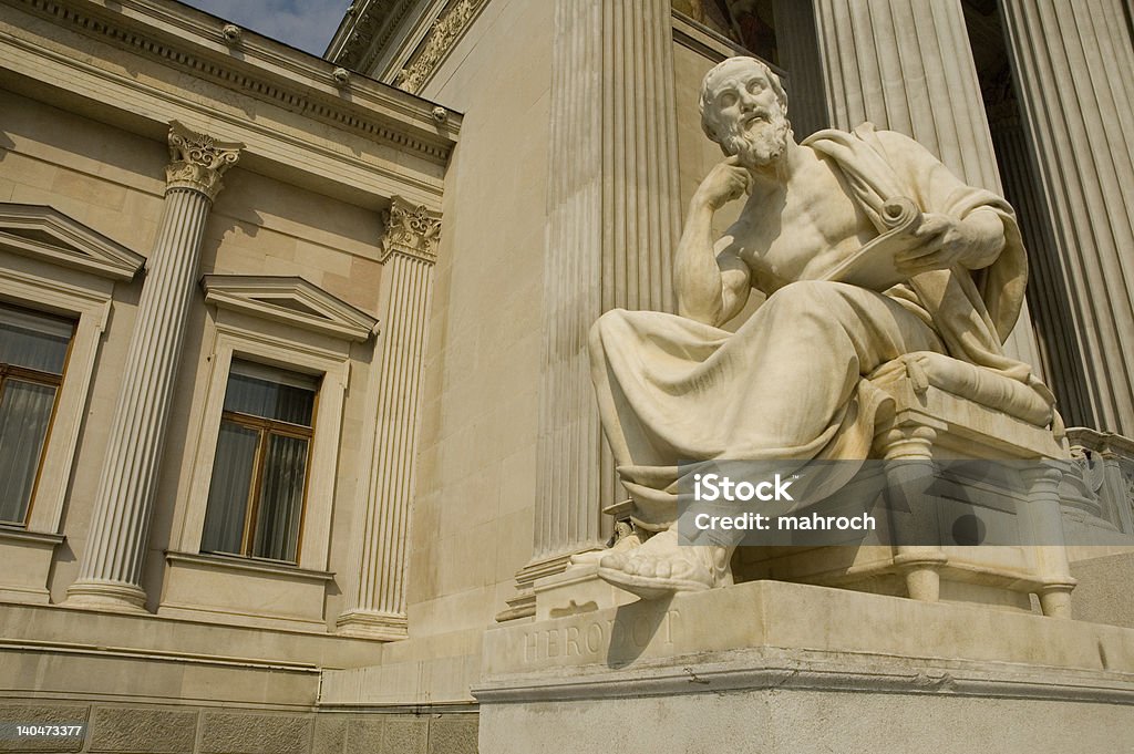 Statue of sitting philosopher on chair Statues of greek philosopher in front of building of Austrian parliament in Vienna. Philosophy Stock Photo