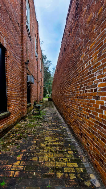 istock Red Brick Alleyway with Blue Sky Above 1404734232