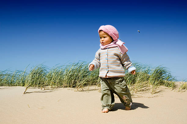 little asian girl walking at the beach stock photo