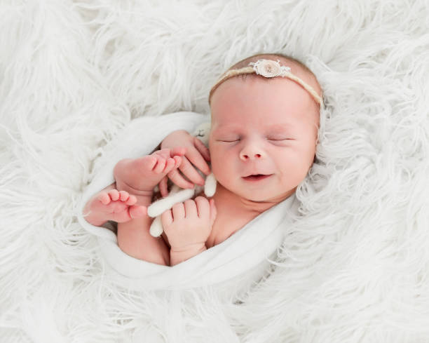 istock newborn baby sleeping with a small toy 1404735503