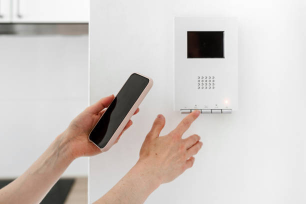 istock Woman with smartphone managing wireless devices in apartment 1404735541
