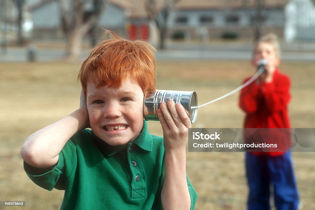 Two boys playing telephone with cans and string  Boys playing on a can "telephone" Telephone Stock Photo