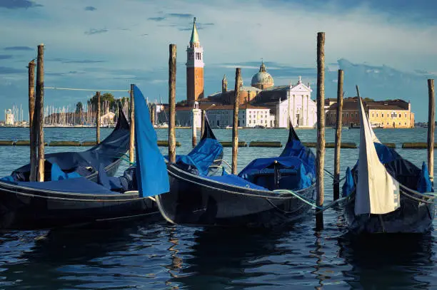 Venice, Wide angle shot of gondolas or gondole and San Giorgio Maggiore church landmark on background. Italy, Europe.
