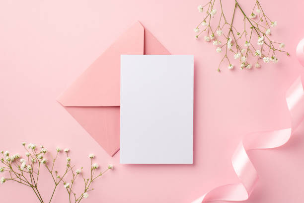 koncepcja zaproszenia ślubnego. widok z góry zdjęcie różowej koperty papierowej karty różowa kręcona wstążka i białe kwiaty gipsówki na izolowanym pastelowym różowym tle z pustą przestrzenią - greeting card envelope letter pink zdjęcia i obrazy z banku zdjęć