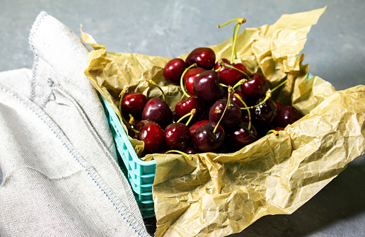 Fresh cherry fruit in basket on wooden table