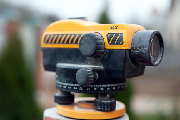 surveying measuring equipment level transit on tripod at construction building area site - tachymeter imagens e fotografias de stock