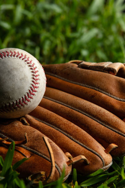 istock Baseball Positioned in Side View on Top of Mitt in Grass 1404738804