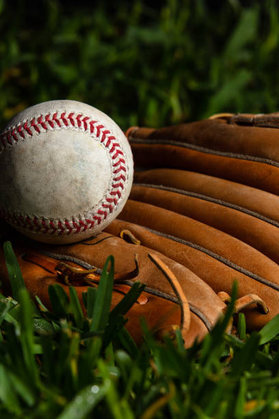 istock Baseball Positioned on Baseball Glove with Grass 1404738808