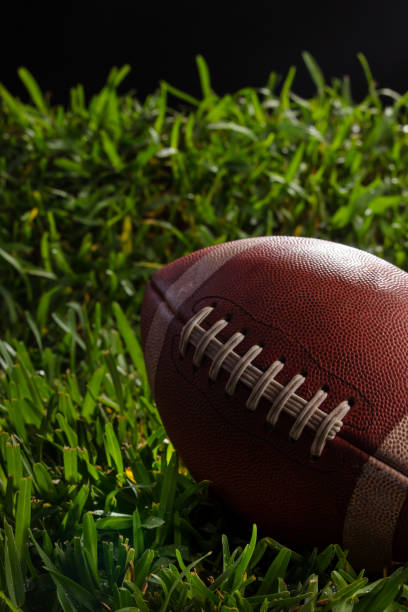 istock Football Resting on Grass with Black Background 1404738823