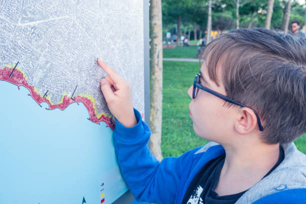 istock Tourist boy examines the map on the sign 1404743387