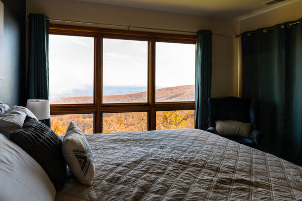 casa appartamento rustico con vista finestra camera da letto dal letto di wintergreen, virginia blu cresta vista montagna in autunno autunno stagione autunnale con fogliame arancione - cabin indoors rustic bedroom foto e immagini stock