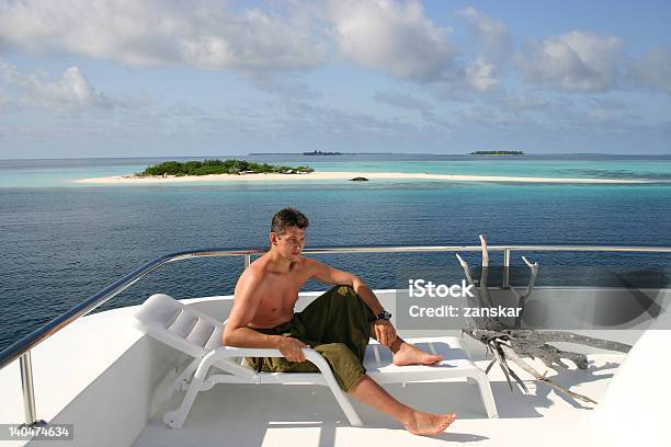 Foto de Homem Relaxando Em Uma Espreguiçadeira Na Viagem De Barco e mais fotos de stock de Adulto