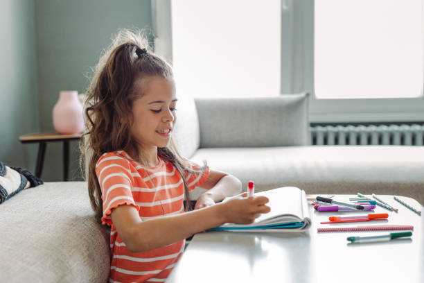 istock Creative little girl draws at home 1404747273
