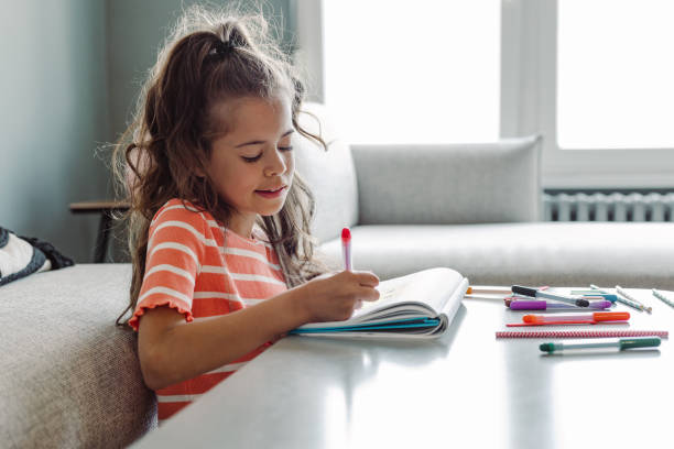 istock Creative little girl draws at home 1404747274
