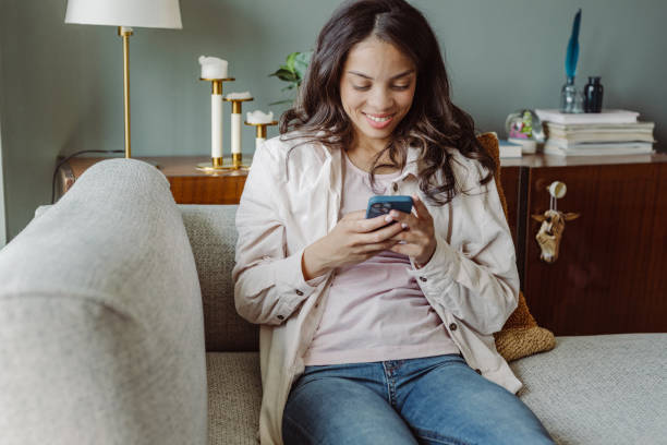 istock Young woman using mobile phone at home. Scrolling through social media 1404747502