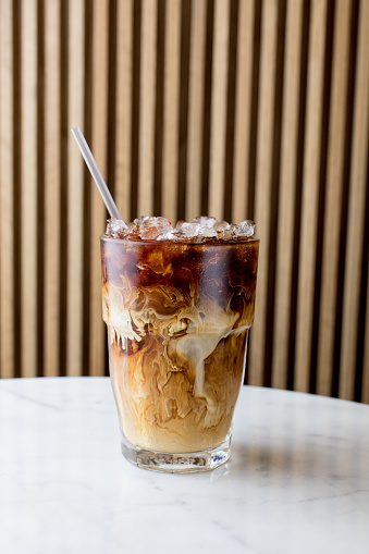 beautiful cold brew with cream swirling on white marble table in Seattle, Washington, United States