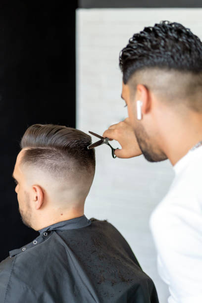 istock professional barber cutting a man's hair 1404748386
