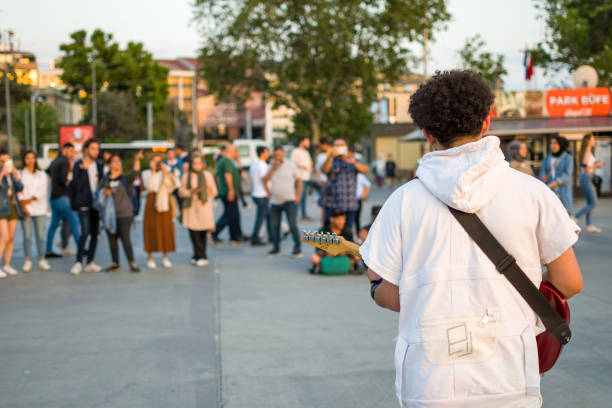 Istanbul, Turkey - June 21, 2022: Musician play guitar busking on Kadikoy Square in of Istanbul.