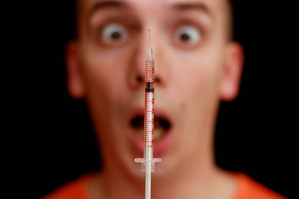 Frightened face - injection Frightened face of a man and a syringe - fear of injection. phobia stock pictures, royalty-free photos & images