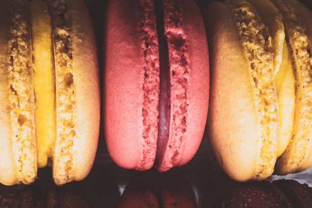Close up of vibrant colored French macarons stacked together in a takeout box