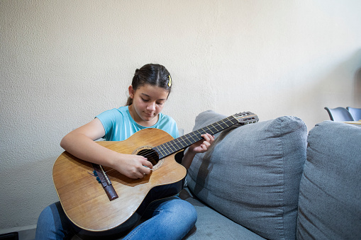 teenage girl playing the guitar