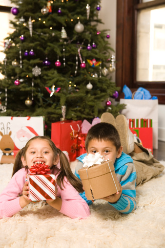 Hispanic brother and sister with presents at christmas