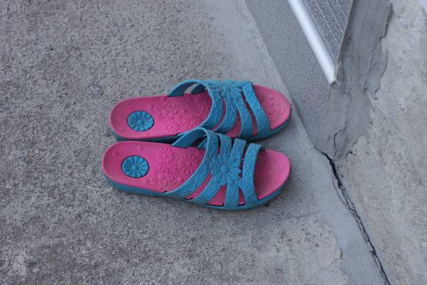 istock two plastic summer red blue sandals stand on gray asphalt 1404752358