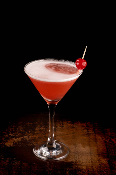 istock angle view martini glass with cherry and foam dark background on wooden table 1404755591