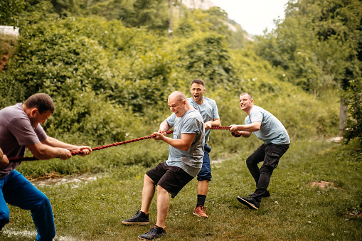 Two business person playing tug-of-war.