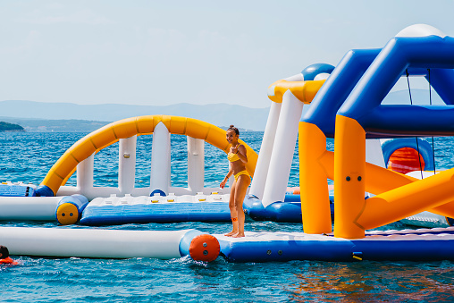 Vacation or holiday concept.Inflatable Floating Water Park.Children on Inflatable entertainment water attractions and slides on sea.Water inflatable slide attraction. recreation concept on the water.