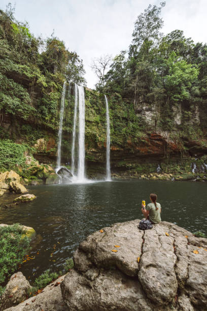 istock Woman looking at the waterfall, while sitting down 1404762790