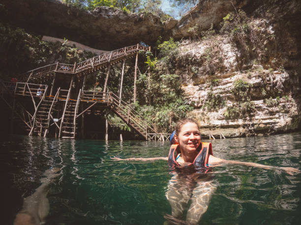 istock Smiling woman swimming in Cenote 1404763410