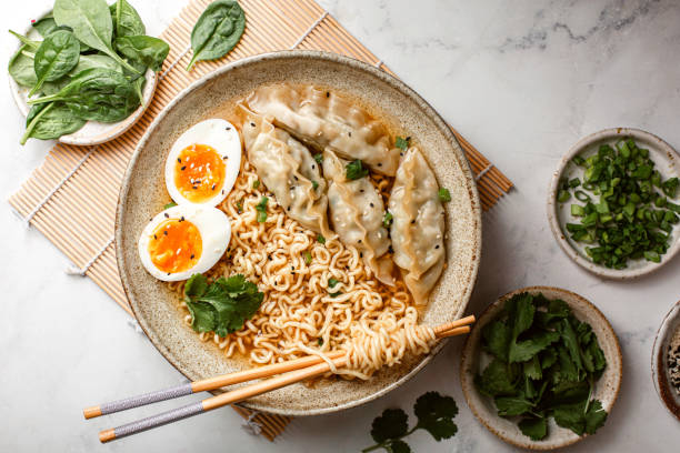 istock Asian Ramen noodle soup with dumplings, egg and parsley 1404763525