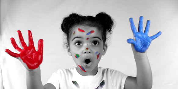 Cute toddler girl with paint on both of her hands