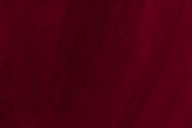 Abstract background of dark red-maroon colour to a milk mixture. Abstract beautiful art effect of dark red maroon colour swirls added to milk to create an interesting image background pattern. maroon stock pictures, royalty-free photos & images